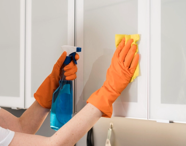 Side view of woman cleaning the kitchen cabinets (1)